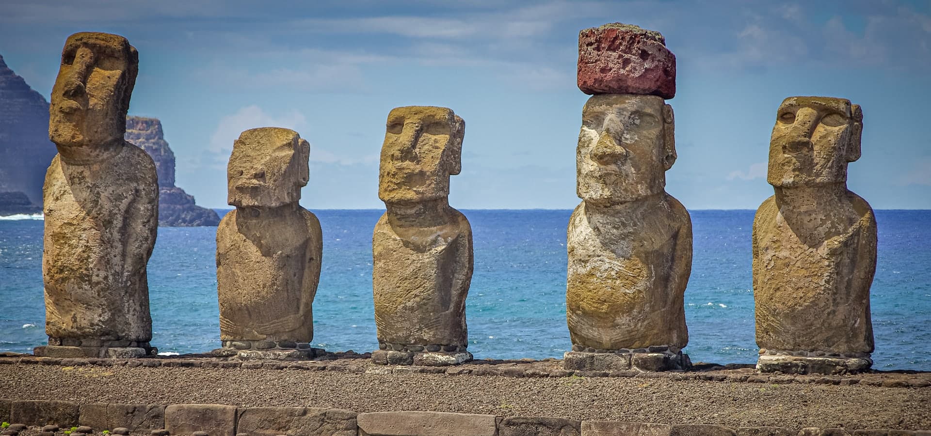 Moai statues along a coastline at low light.